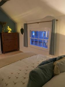 a bedroom with a bed and a window at Mingo Cottage in Bewdley