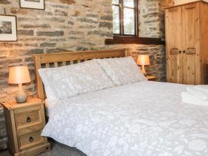 a bedroom with a bed and two lamps on night stands at The Granary in Bucknell