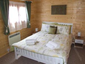 Un dormitorio con una cama blanca con dos toallas encima. en Pennylands Willow Lodge, en Broadway