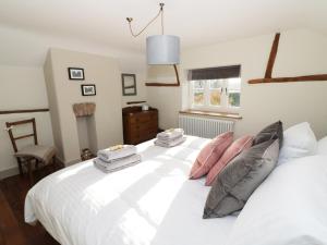 a bedroom with a large white bed with pillows at Ivy Cottage in Great Malvern