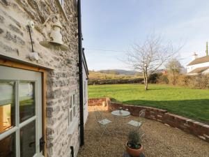 a patio with a table and chairs next to a building at Ivy Cottage in Great Malvern