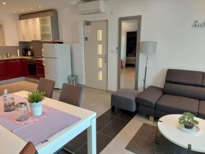 a kitchen and a living room with a table and a couch at Dream View apartment in Cres