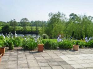 a garden with purple flowers and plants and a pond at Herons in Byford