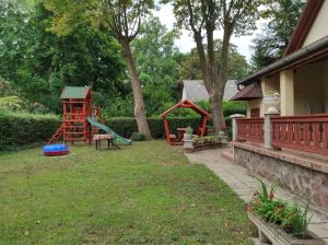 a yard with a playground with a slide and a swing at Balatonszemesi Nyaralóház in Balatonszemes