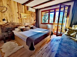 ein Schlafzimmer mit einem großen Bett und einem großen Fenster in der Unterkunft Ribno Alpine Hotel in Bled