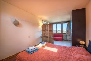 una camera da letto con un letto con un copriletto rosso di Casa Ravacciano a Siena