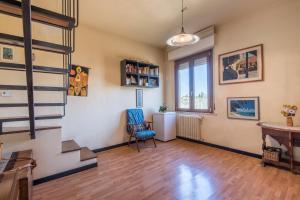 un soggiorno con scala e sedia di Casa Ravacciano a Siena