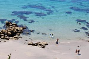 a group of people standing in the water on a beach at Hostal Casa Aurita Adults Only in Sanxenxo