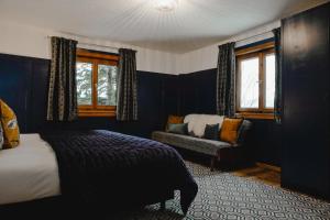 sypialnia z łóżkiem, krzesłem i oknami w obiekcie St Anton 365 w mieście Sankt Anton am Arlberg