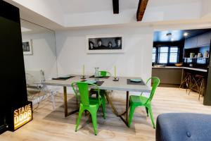 a dining room with a table and green chairs at Large Modern 2 Bedroom Queen Street Apartment in Norwich