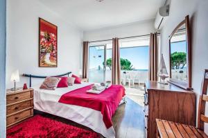 a bedroom with a large bed with a red blanket at Villa Oceano in Patroves +28 photos