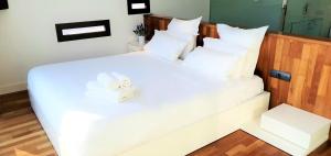 a white bed with a white towel on it at Villa Rufol in Deltebre