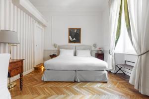 a white bedroom with a large bed and a window at Relais Donna Lucrezia in Rome