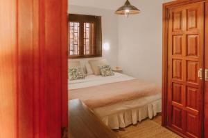 ein Schlafzimmer mit einem Bett in einem Zimmer mit einem Fenster in der Unterkunft Bungalows El Palmital - Adults Only in Playa del Ingles