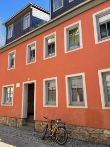 a bike parked in front of a orange building at Jena Botanischer Garten in Jena