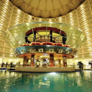 een groot gebouw met een zwembad ervoor bij Rajhans Belliza Luxurious Studio Apartment in Surat