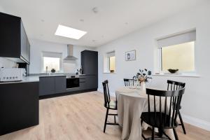 a kitchen and dining room with a table and chairs at Norman Road- Brand new luxury GF Apartment in St. Leonards