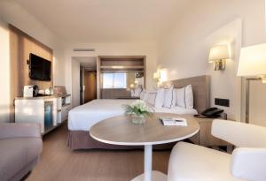a hotel room with a bed and a table at Melia Sitges in Sitges