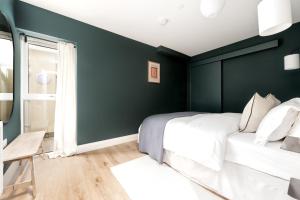 um quarto com paredes verdes e uma cama branca em Norman Road- Brand new luxury GF Apartment em St. Leonards