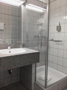 La salle de bains est pourvue d'un lavabo et d'une douche. dans l'établissement Hotel Schweizer Hof, à Cassel