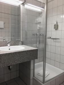 ein Badezimmer mit Waschbecken und Dusche in der Unterkunft Hotel Schweizer Hof in Kassel