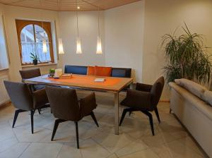 a dining room with a table and chairs and a couch at Ferienwohnung Bleifuss in Altenbuch im Spessart