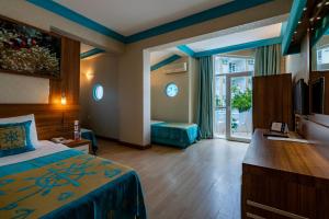 ein Hotelzimmer mit einem Schlafzimmer mit einem Bett und einem Bad in der Unterkunft Miarosa Kemer Beach in Kemer