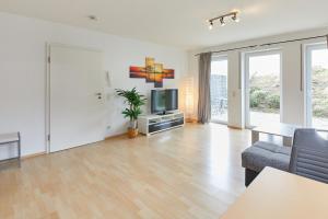 uma sala de estar com uma televisão e um sofá em Am Weinberg em Bernkastel-Kues