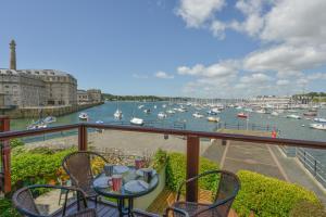 a balcony with a table and chairs and a view of a harbor at The View in Plymouth
