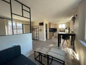 Una sala de estar con una mesa y una cocina. en Le Cosy, en Bourseville