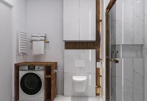 a bathroom with a washing machine and a toilet at LUX Apartament Bedzin in Będzin