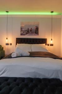a bedroom with a large bed with lights on it at Willow Studio in Leeds