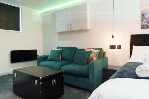 a living room with a green couch and a bed at Willow Studio in Leeds