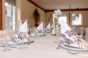 a table with wine glasses and napkins on it at Pension Zum Lindeneck in Lübz