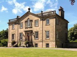 a large brick house with a grass field in front at Dalvey House in Forres