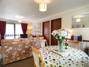 ein Wohnzimmer mit einem Tisch und einer Blumenvase in der Unterkunft Chy Lowenna in Saint Cleer