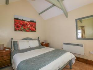 a bedroom with a bed and a large mirror at Cosy Cottage in Liskeard