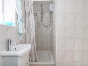 une salle de bain blanche avec une douche et un lavabo dans l'établissement Bre An Mor, à Germoe 16 autres photos