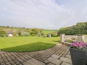 un jardin avec une passerelle en briques et de l'herbe verte dans l'établissement Bre An Mor, à Germoe