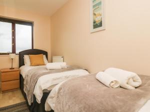 a bedroom with two beds and a window at Sea Horses in Marazion