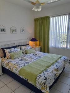 a bedroom with a large bed with a green blanket at 37 Key Largo in Kingsborough