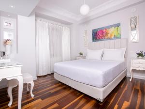 Dormitorio blanco con cama blanca y escritorio blanco en Ascot Hotel Büyükada en Buyukada