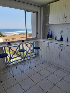 a kitchen with a table and chairs and a view of the ocean at 37 Key Largo in Kingsborough