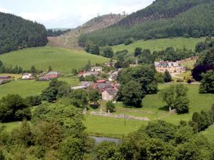 a small town in the middle of a green field at Happy Union Stables in Abbey-Cwmhir