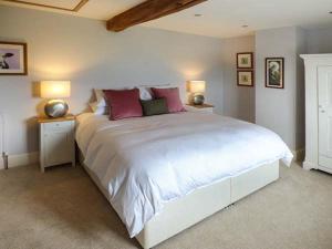 a bedroom with a large white bed with two lamps at Ox Hey Barn in Bolton by Bowland