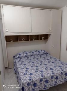 Un dormitorio con una cama con un edredón azul. en Tortolì-Porto Frailis-Arbatax, en Àrbatax
