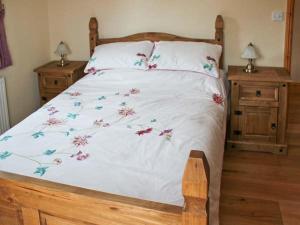 a bedroom with a bed with flowers on it at Moat Farm Cottage in Wood Dalling