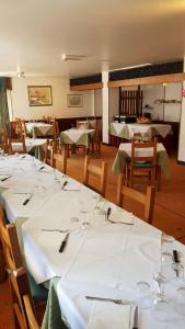 un comedor con mesas y sillas blancas en Hotel Hermitage en Sestriere