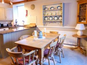 - une cuisine avec une table et des chaises en bois dans l'établissement Gavel Cottage, à Bowness-on-Windermere