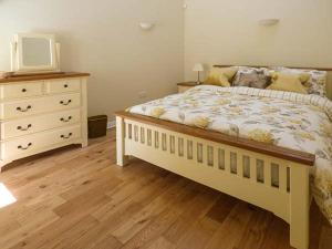 um quarto com uma cama grande e uma cómoda em Setch Barn em Masham